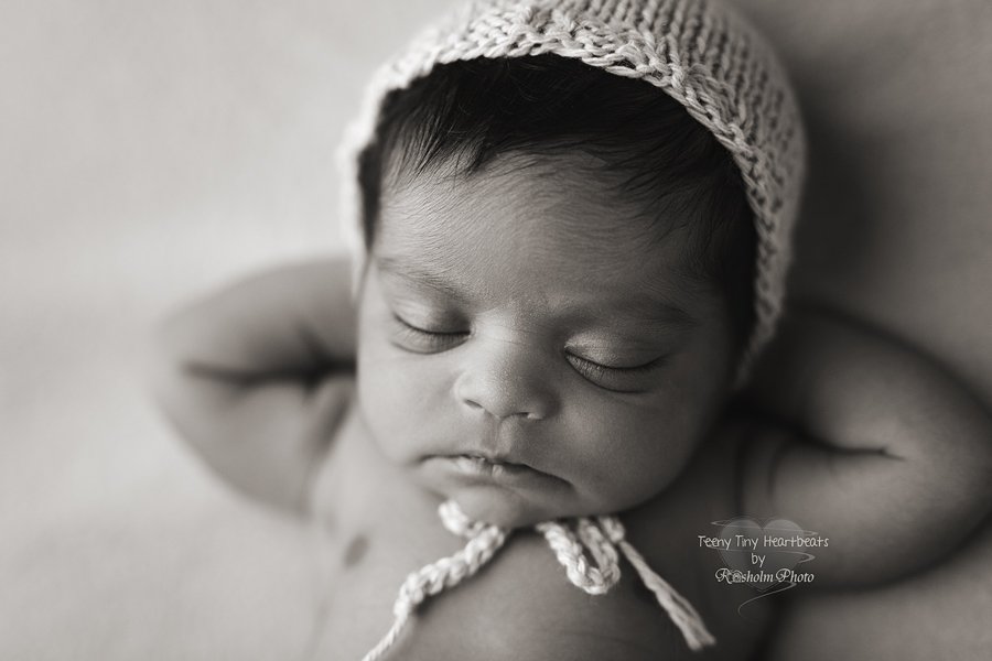 nyfødt sovende med hænderne bag hovedet i sort hvid