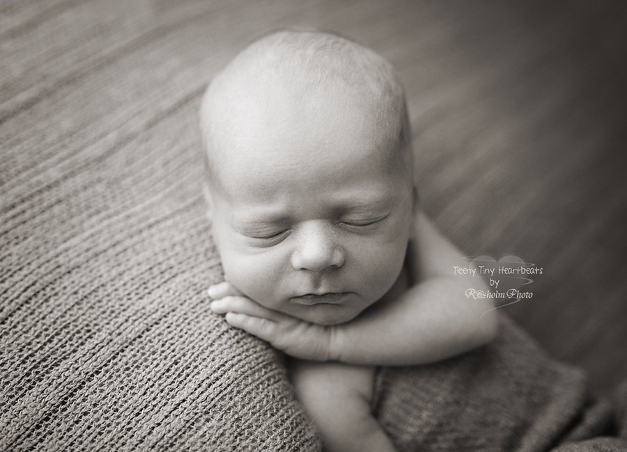 newborn dreng sovende på tæppe i sort hvid