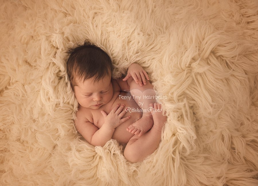 billede af nyfødt dreng sovende i creme tæppe