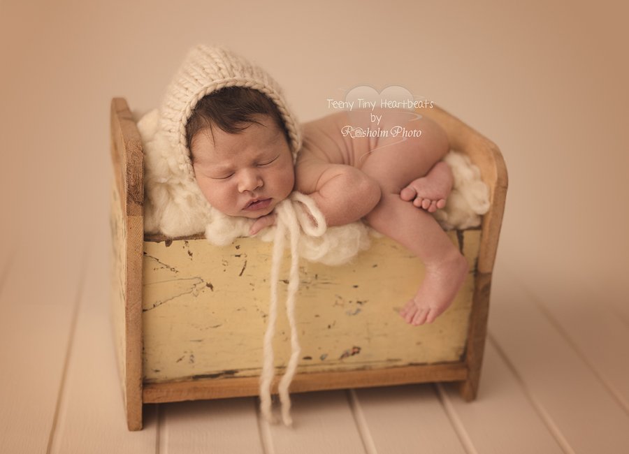 spædbarn sovende med hue på seng i gul hos fotograf i silkeborg